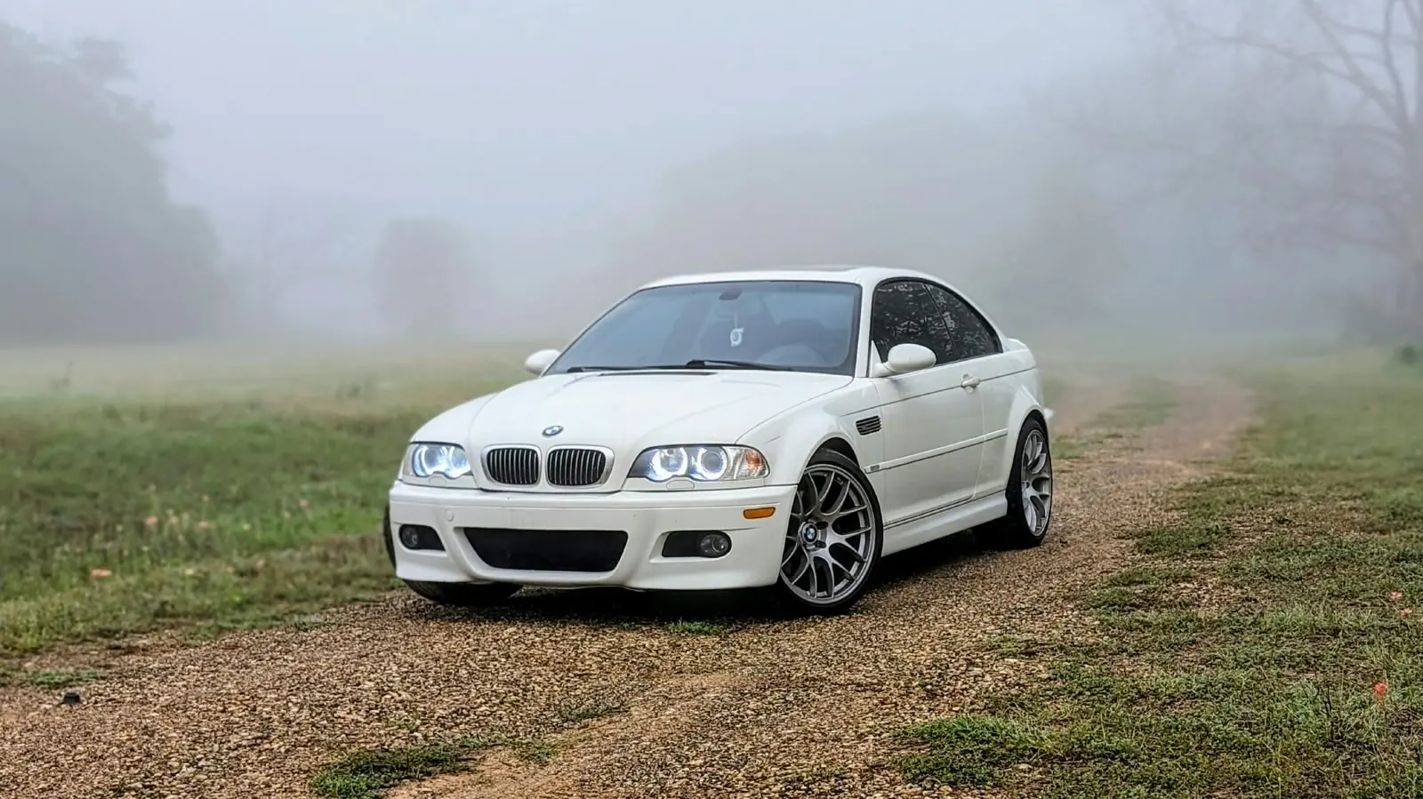 White BMW M3 on a foggy country road