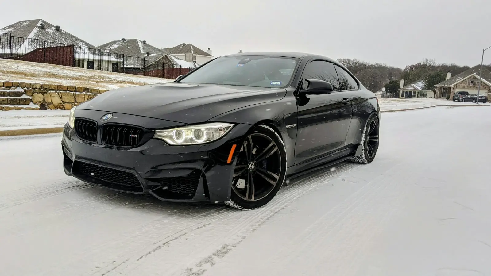 Black BMW M4 coupe on a snow-covered street