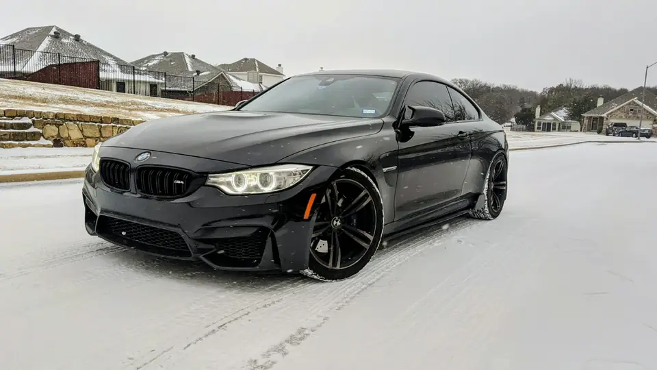 Black BMW M4 on a snowy road