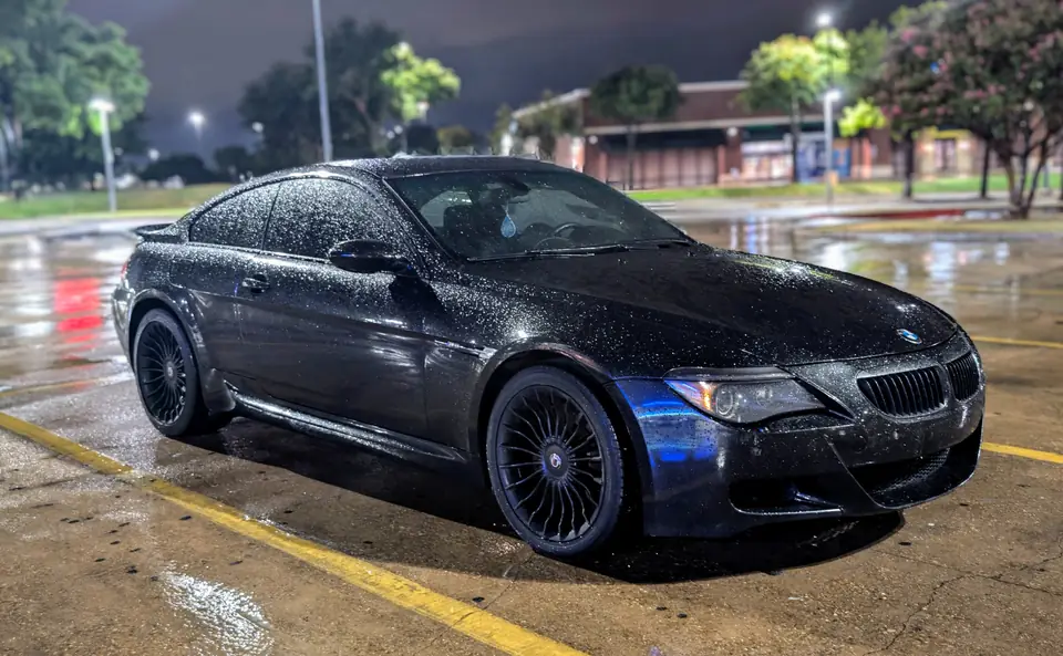 Black BMW M6 on wet pavement